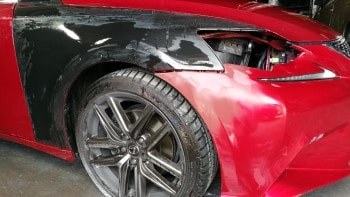 Fender dent repair on a red car